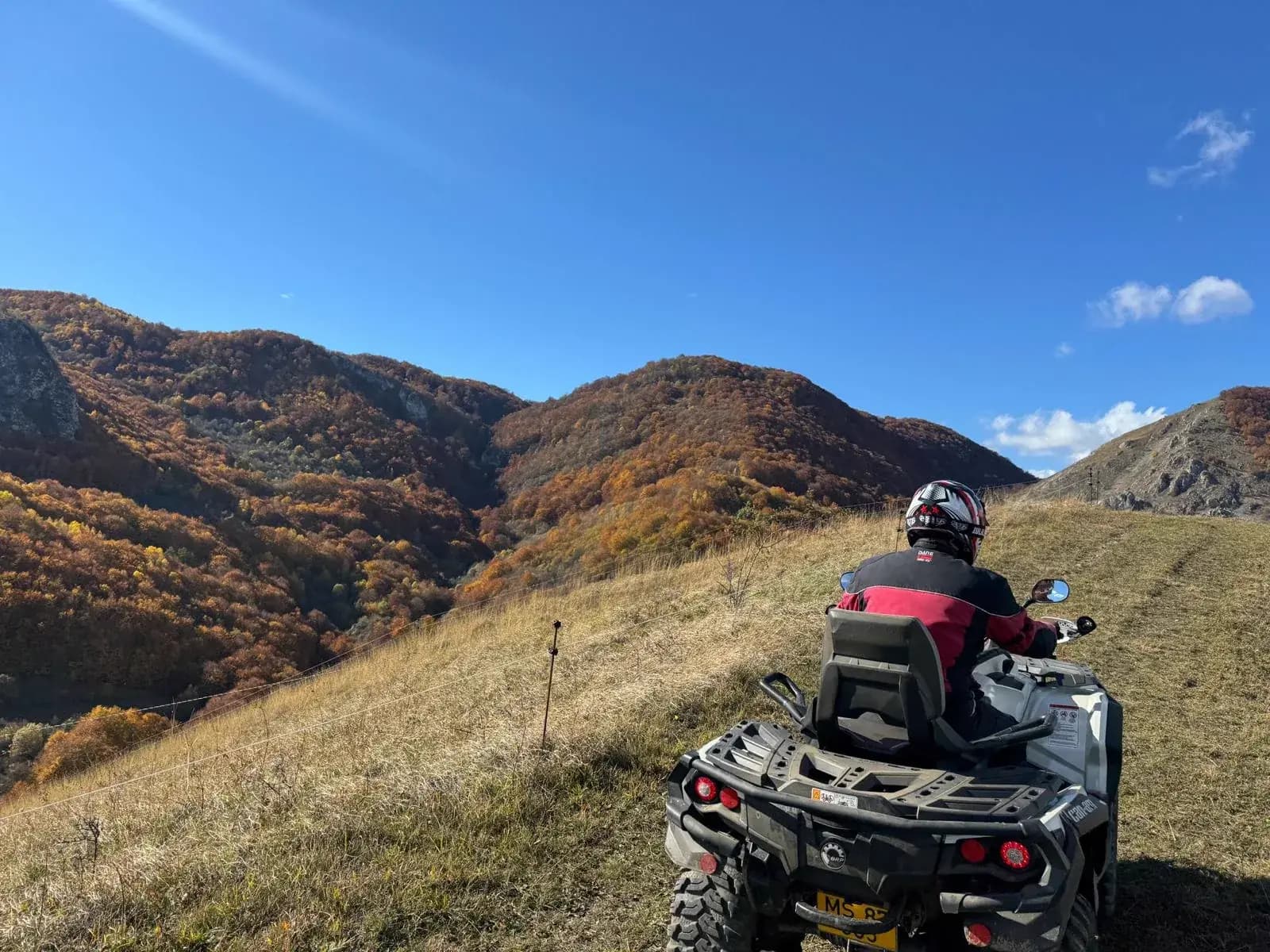 A rider overlooking a dramatic autumn valley from a ridge